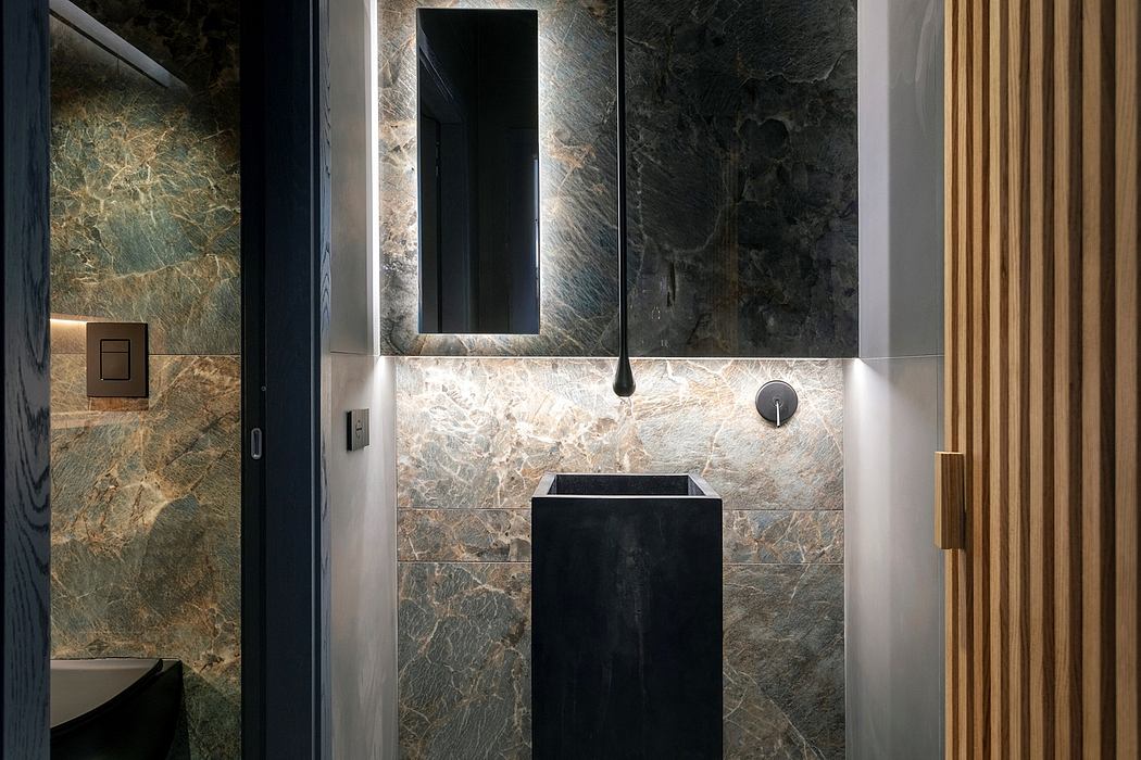 A modern bathroom interior with sleek black fixtures, natural stone walls, and wood accents.