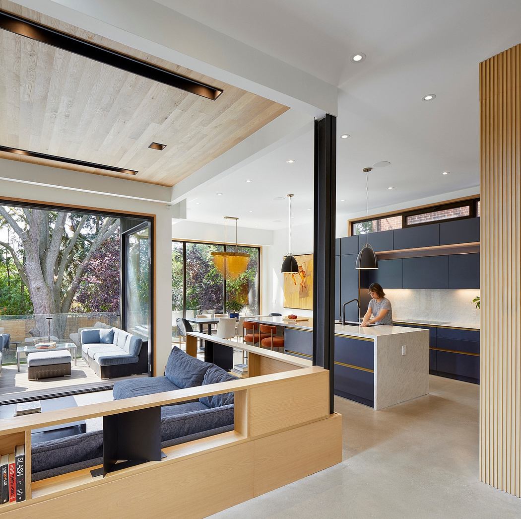 A spacious, modern kitchen and living area with wood-paneled ceilings, large windows, and sleek, minimalist design.