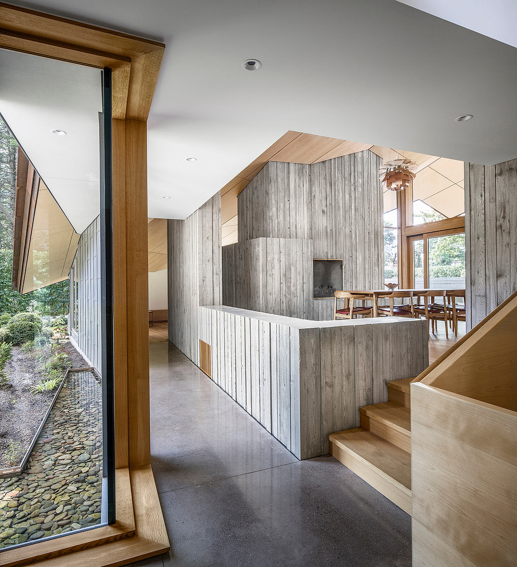 Spacious modern interior with wood paneling, geometric windows, and concrete floors.