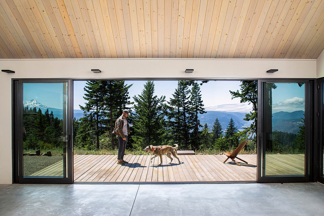 Modern wooden structure with large windows showcasing scenic mountain landscape.
