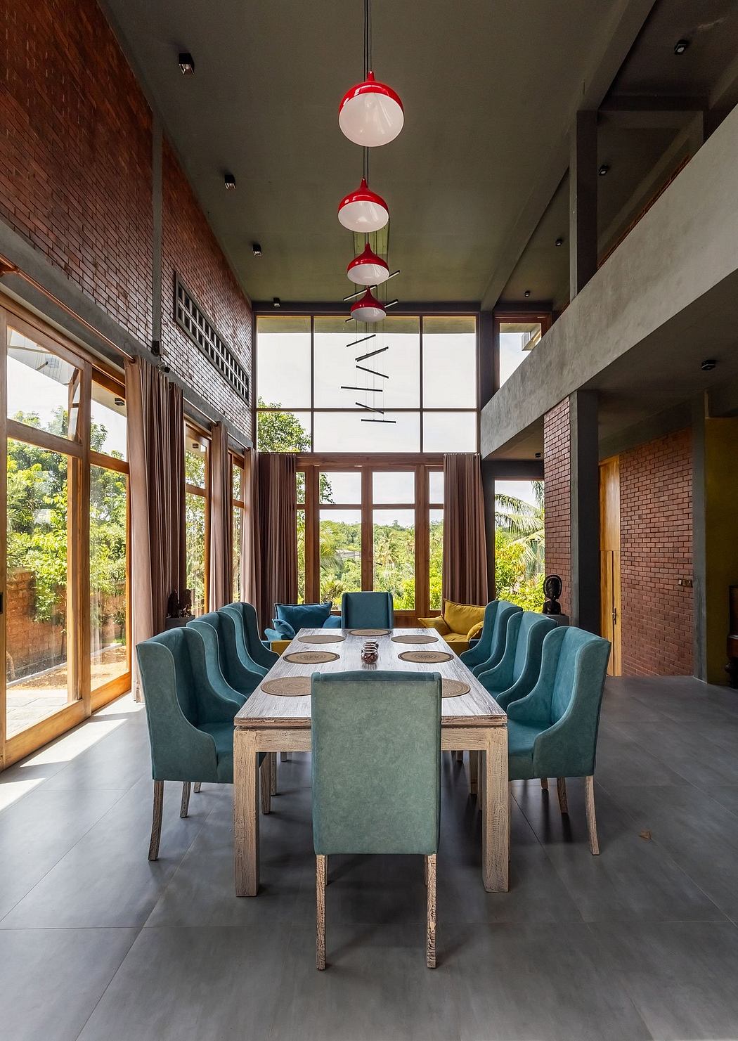 Sleek modern dining room with brick walls, large windows, and vibrant teal chairs.