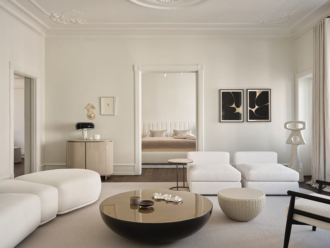 This elegant room features ornate moldings, high ceilings, and a mix of modern and vintage furnishings.