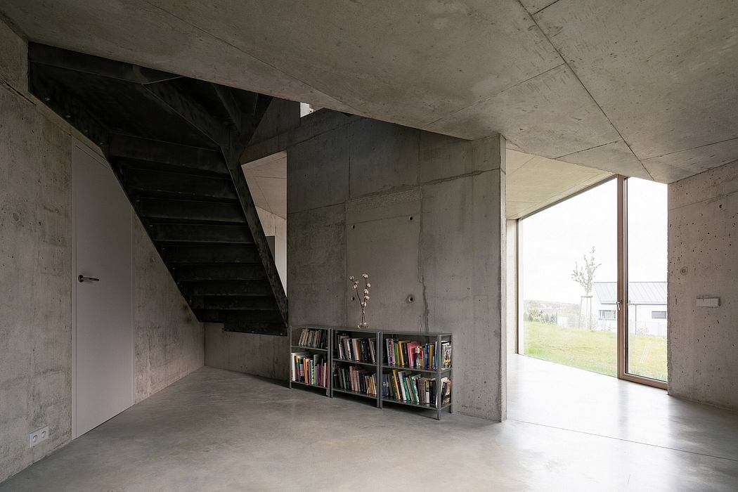 Minimalist concrete interior with exposed ceiling beams and floor-to-ceiling windows.