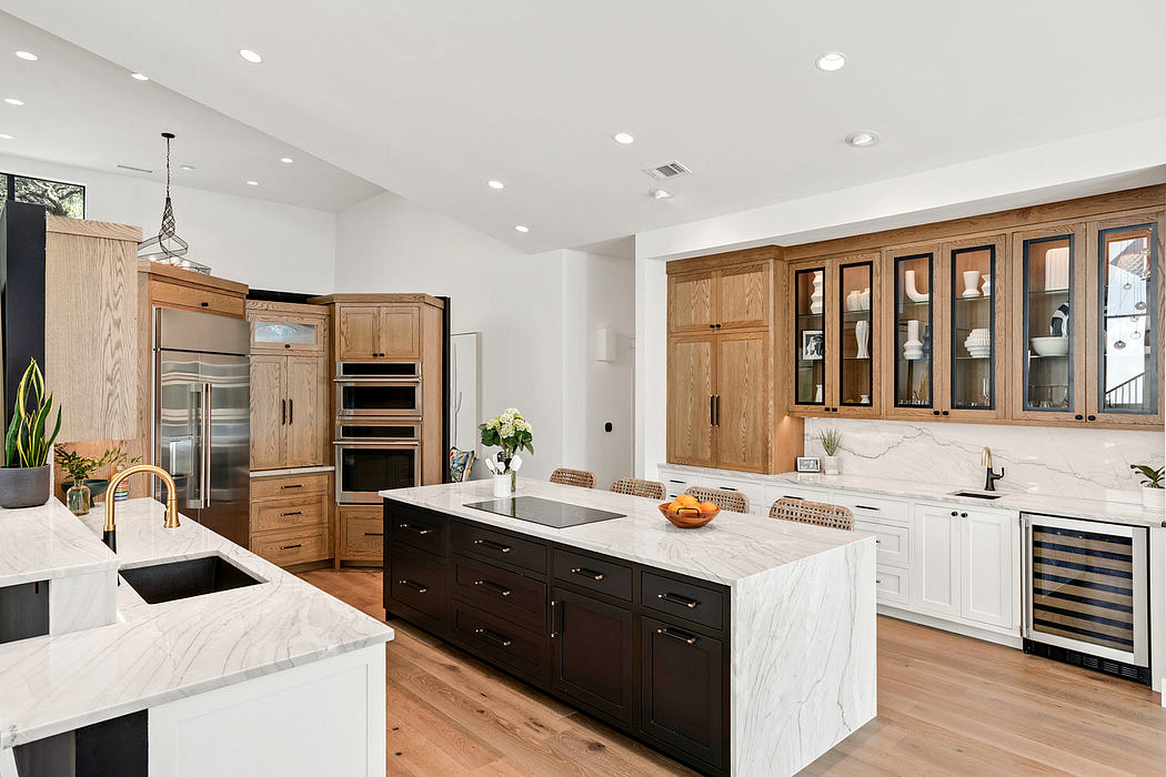 Spacious modern kitchen with wood cabinetry, marble countertops, and stainless steel appliances.