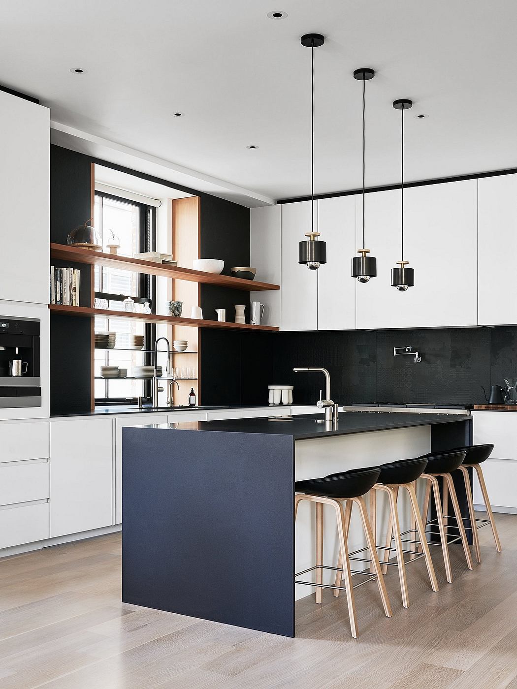 Sleek modern kitchen with contrasting black and white tones, floating wood shelves, and pendant lights.