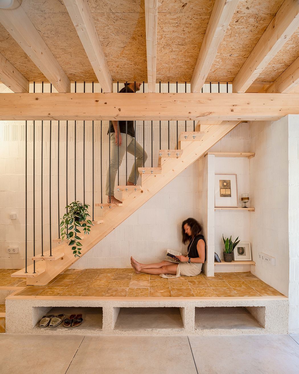 A cozy, open-concept space with a wooden staircase, natural lighting, and minimalist decor.