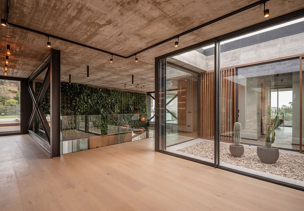 Spacious open-plan interior with concrete ceiling, wood floors, and floor-to-ceiling windows.
