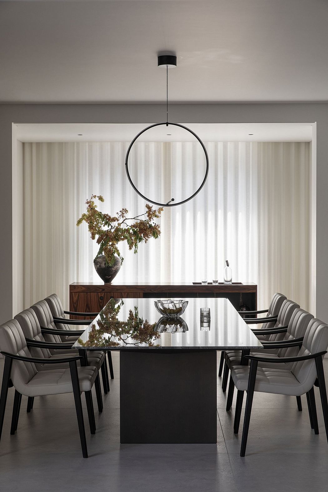 Elegant dining area with minimalist decor, circular lighting, and floral centerpiece.