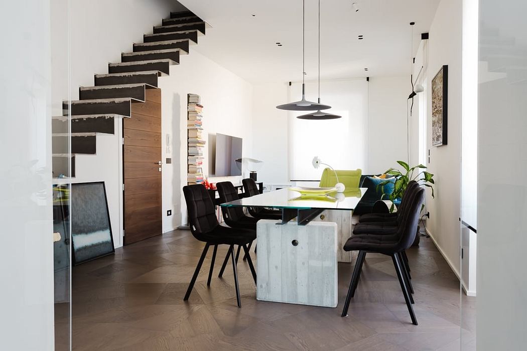 Sleek, modern interior with minimalist staircase, dining table, and pendant lighting.