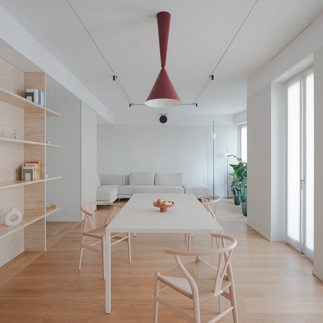 Elegant minimalist interior with modern furnishings, wood accents, and a striking red pendant light.