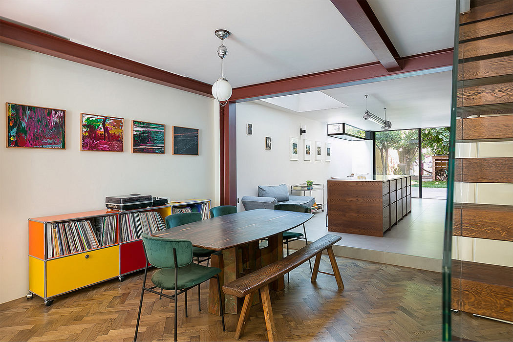 Eclectic living room with wooden beams, shelves, and vibrant artwork.