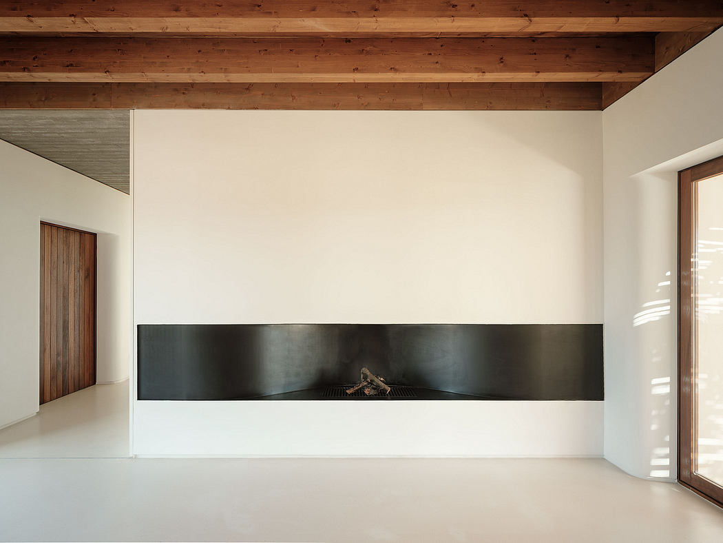 Clean modern interior with wooden beams, minimalist fireplace, and large windows.