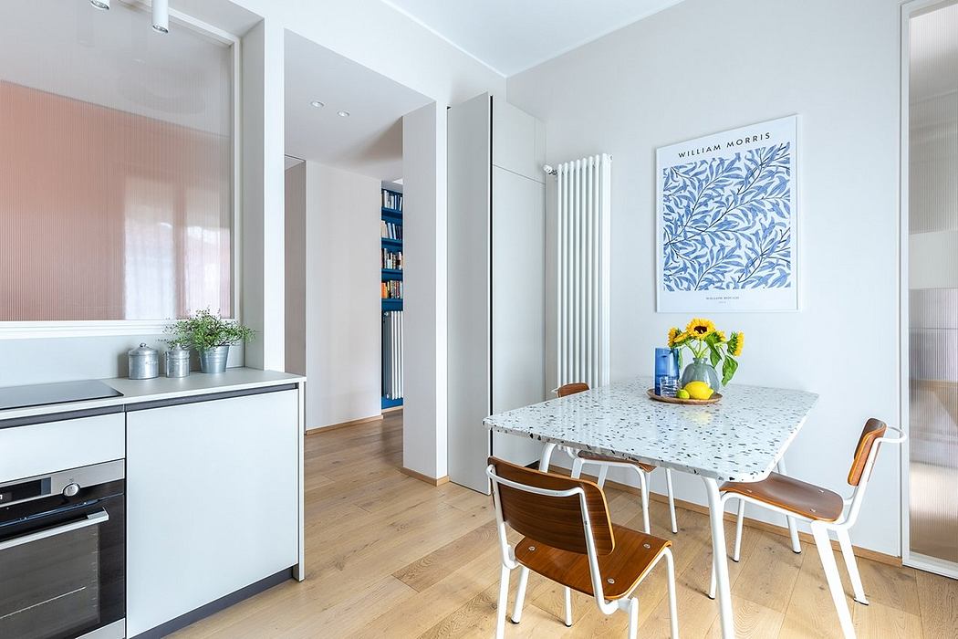 Modern kitchen with terrazzo countertop, wooden chairs, and William Morris artwork.