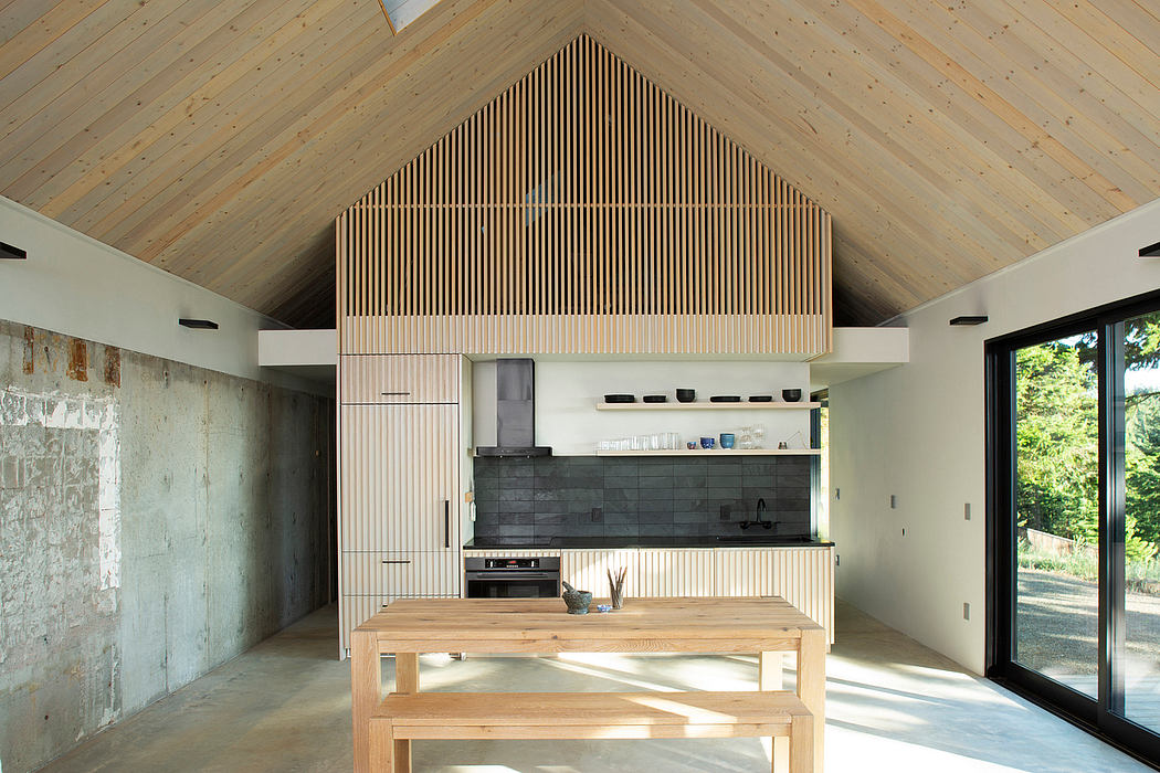 Rustic kitchen with vaulted wooden ceiling, slatted accent wall, and large sliding doors.