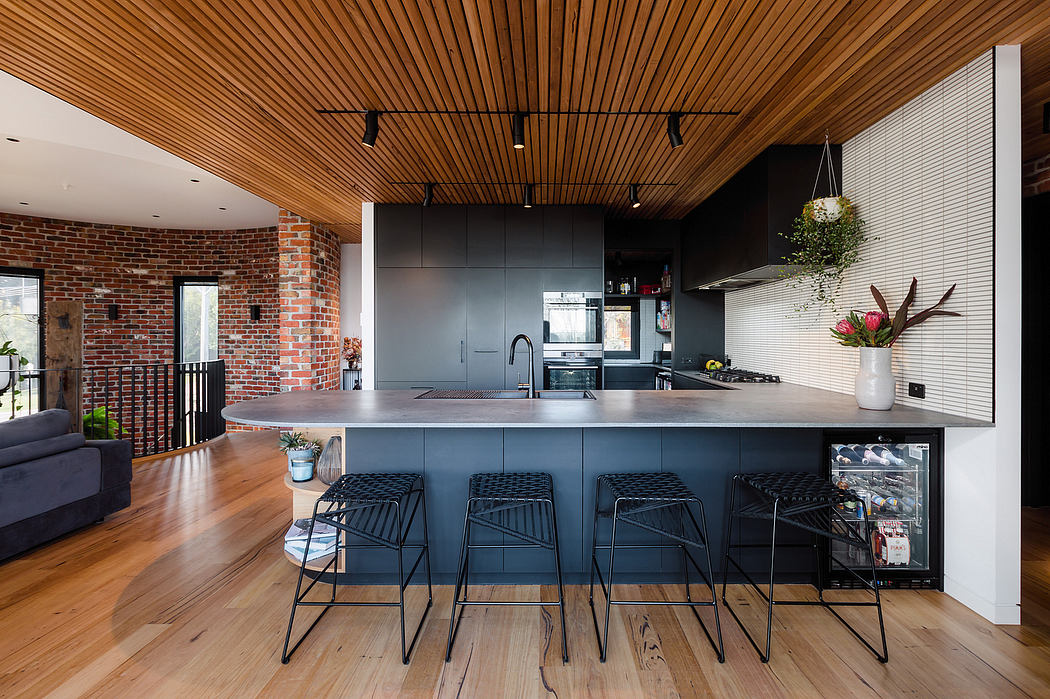 Sleek kitchen with black cabinetry, wooden ceiling, and brick walls creating a modern industrial vibe.