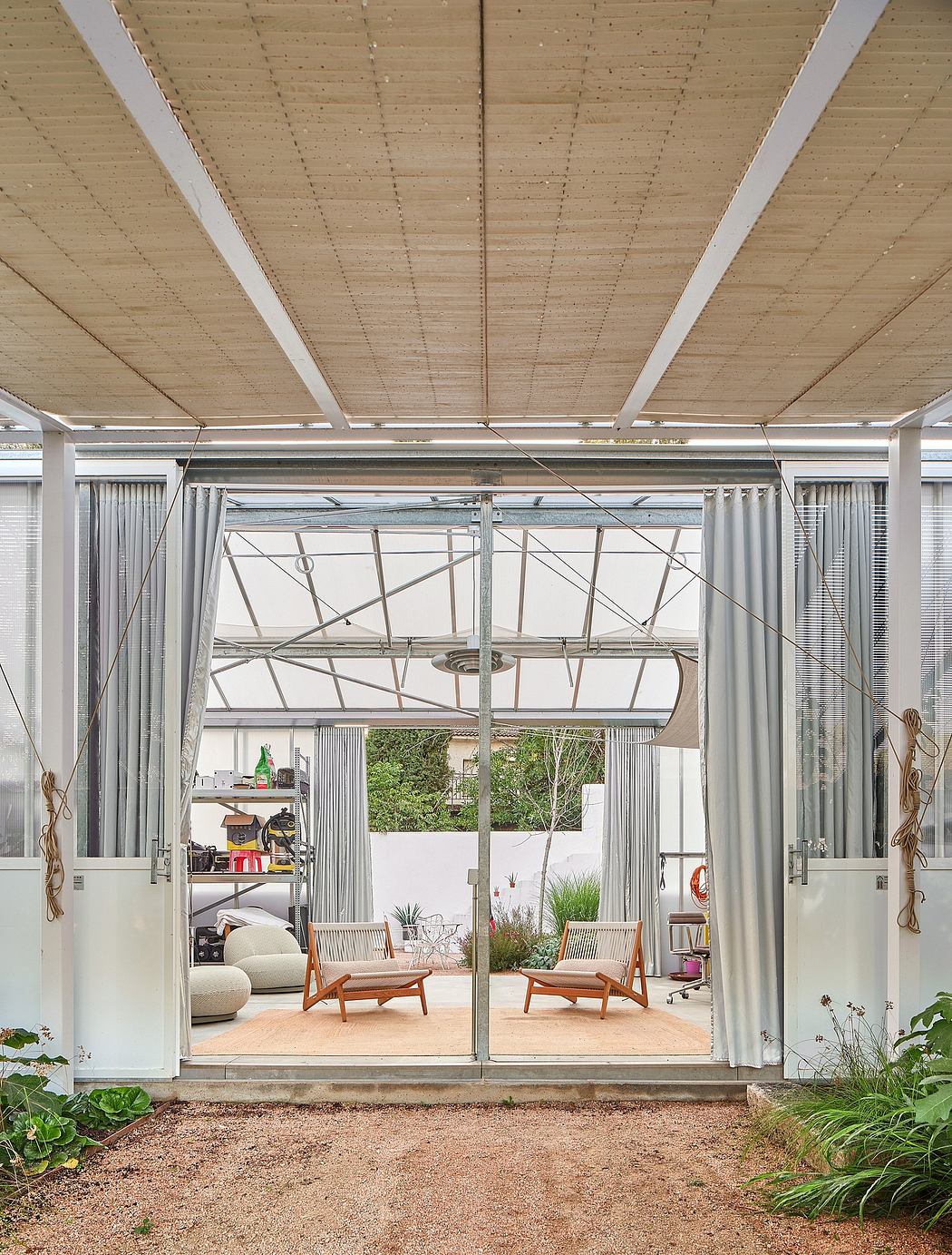 Airy garden studio with wood beamed ceiling, large windows, and comfortable seating.