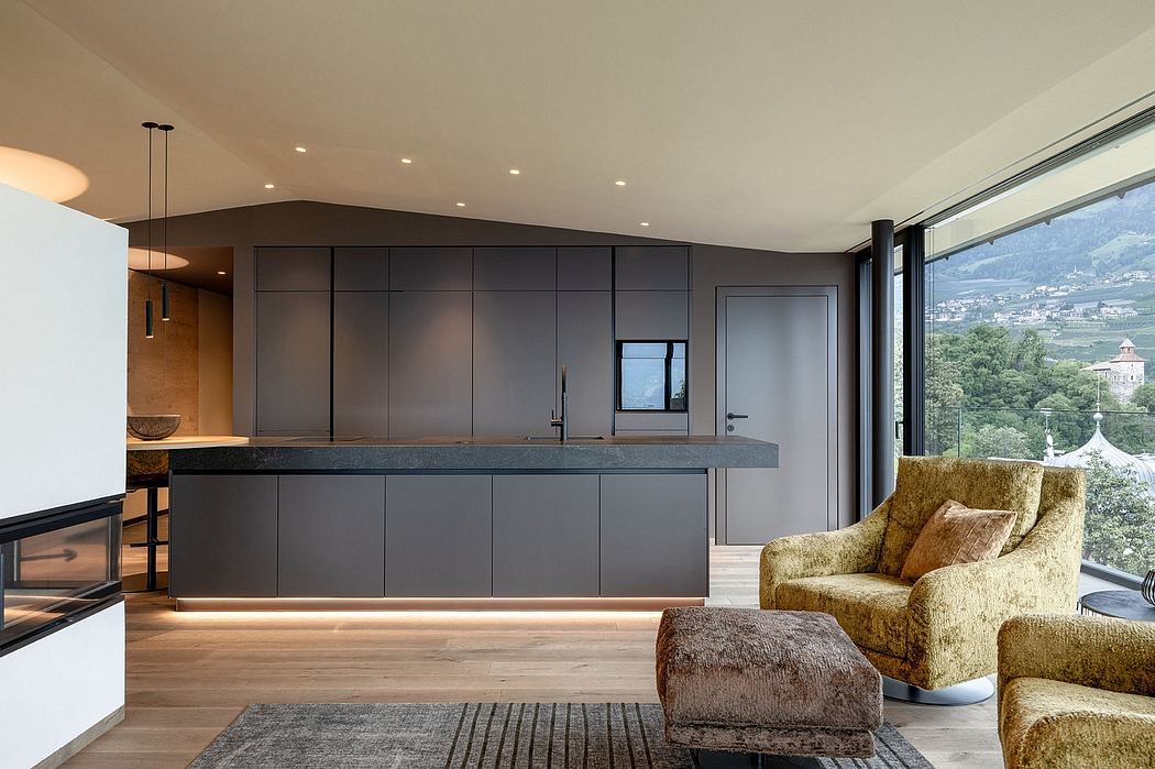 Modern kitchen with sleek dark cabinets, large windows overlooking a scenic landscape.