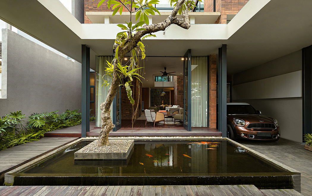 Sleek, modern home with lush greenery, reflecting pool, and luxury car in courtyard.