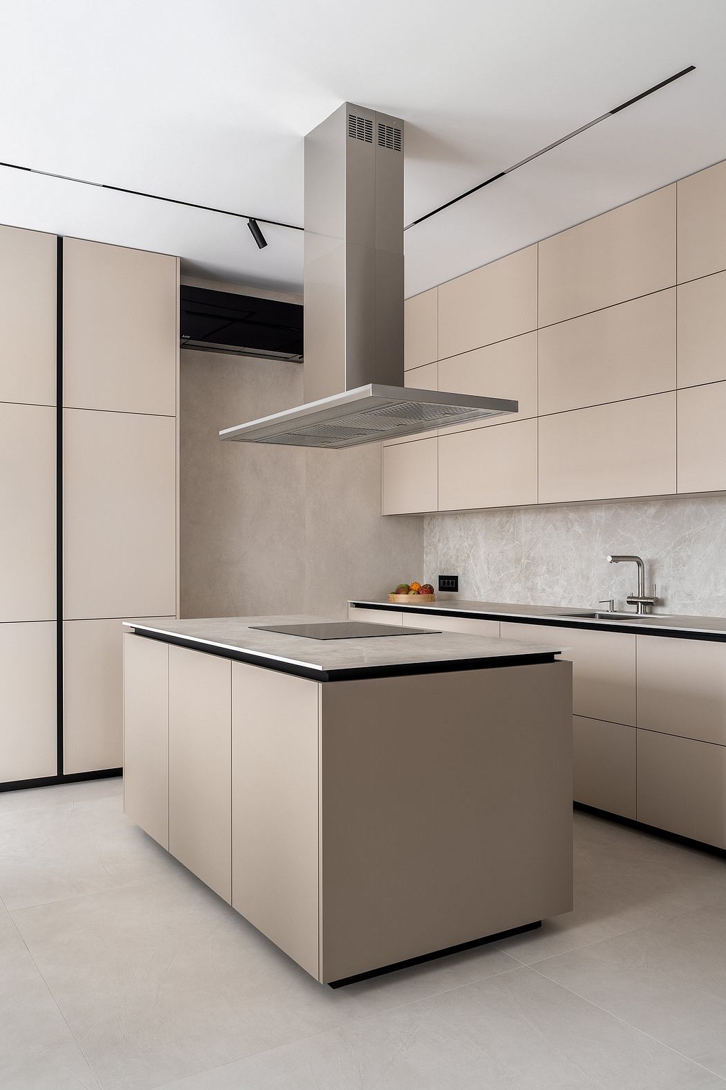 Modern kitchen with minimalist beige cabinets, sleek appliances, and a central island.