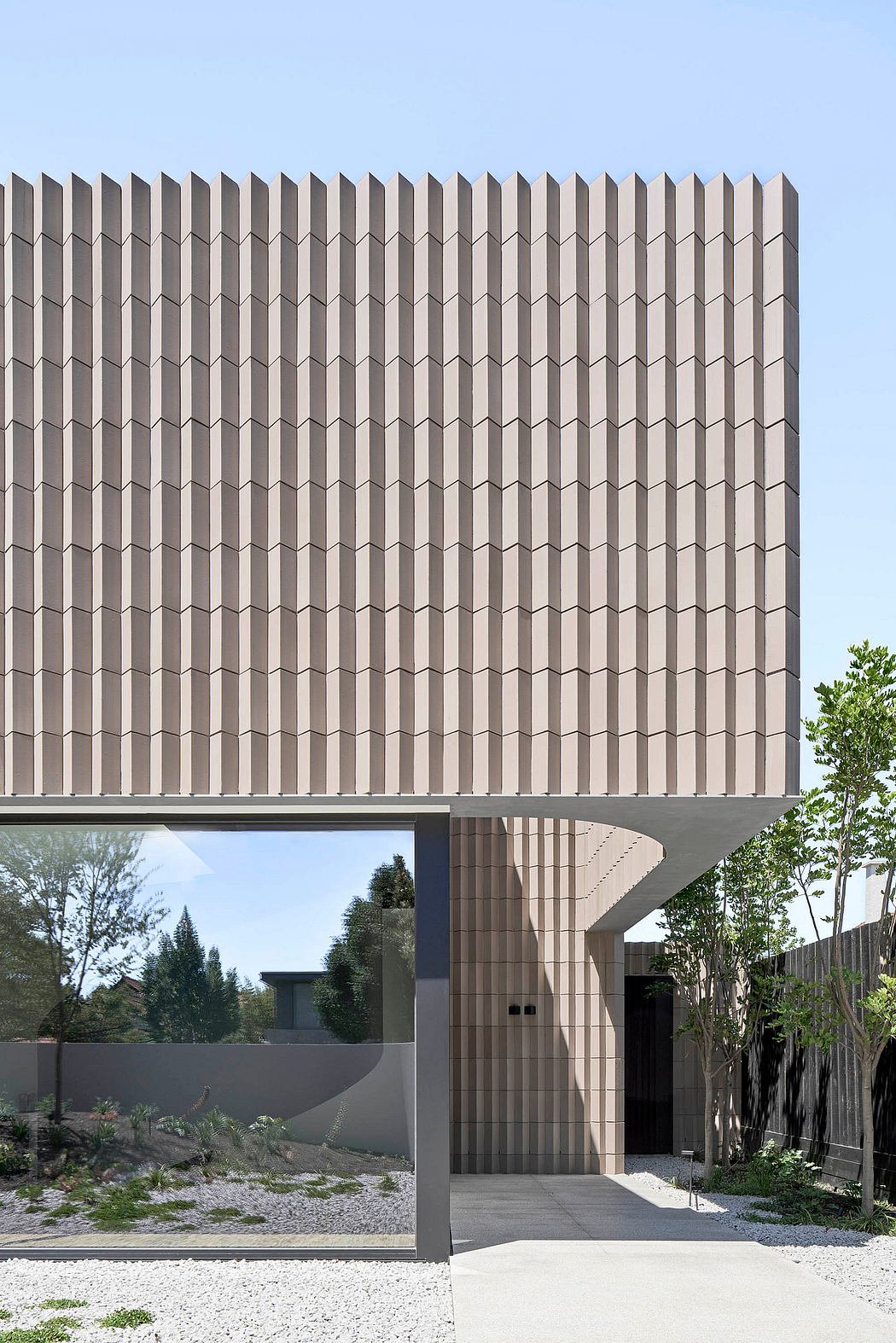 Modern geometric facade with repeating angled elements, creating a striking architectural design.