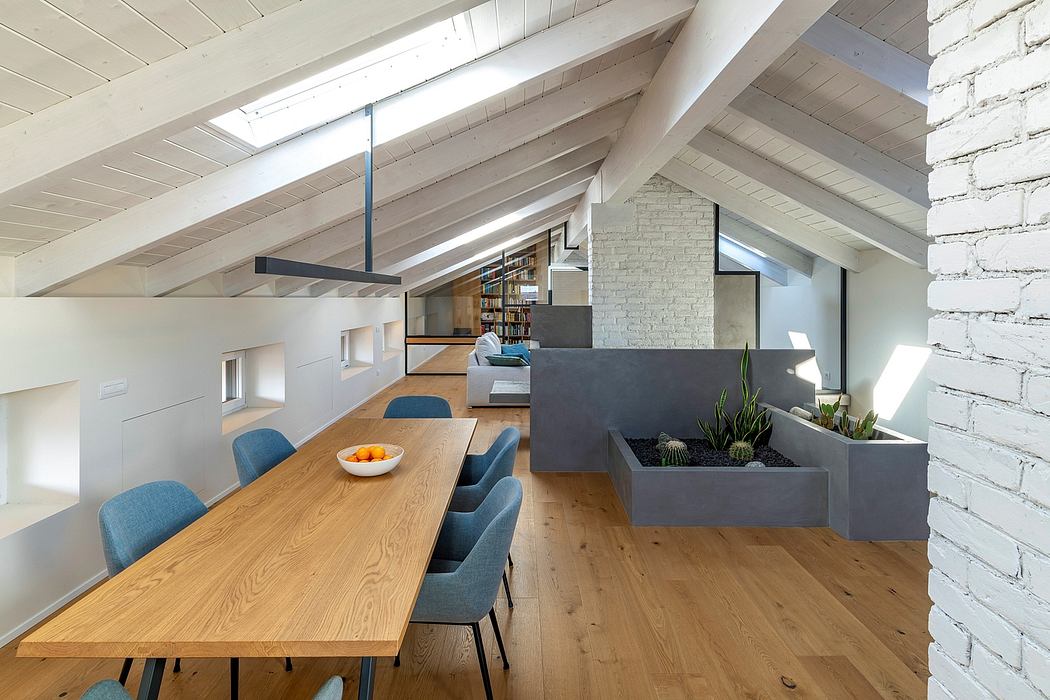 Airy loft with exposed beams, brick wall, and modern furniture arrangement.