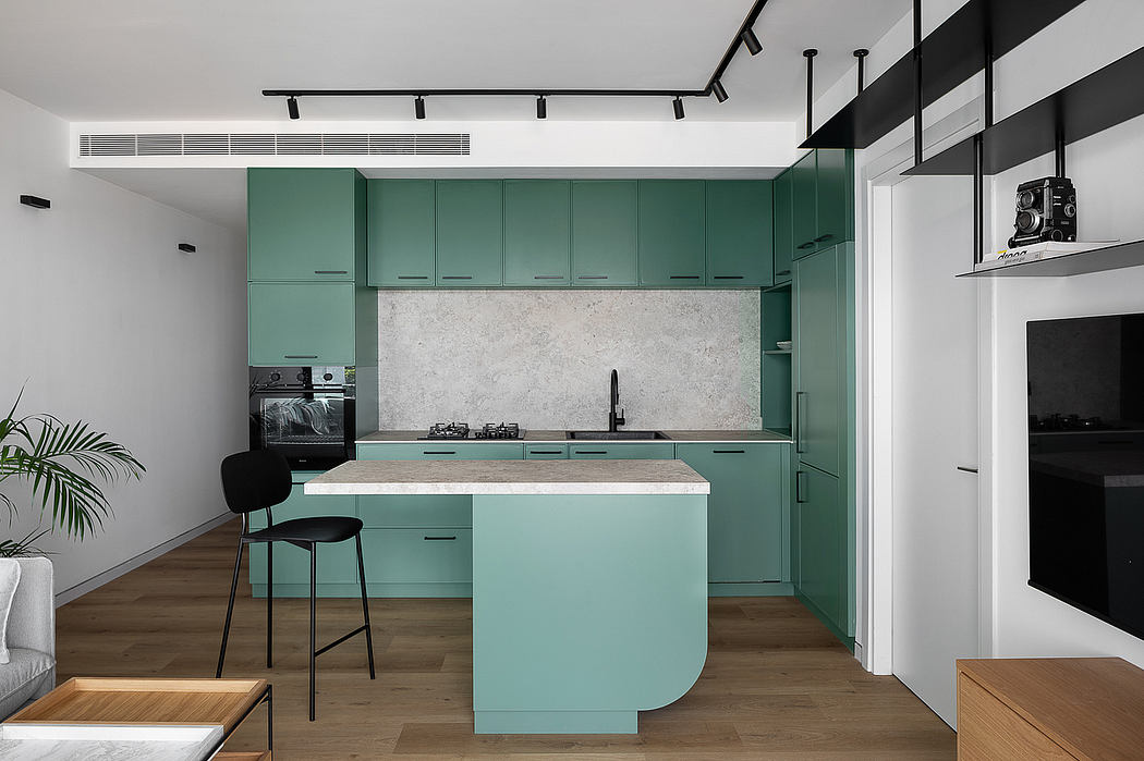 Modern kitchen with minimalist green cabinetry, marble countertop, and sleek black fixtures.