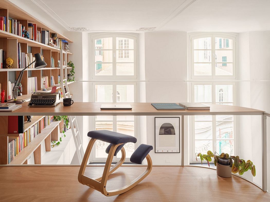 Minimalist office space with bookshelves, large windows, and a rocking chair desk setup.