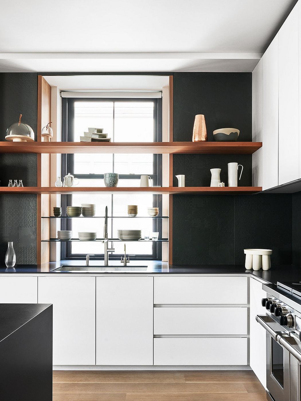 Modern kitchen with minimalist white cabinets, wooden shelves, and large window.