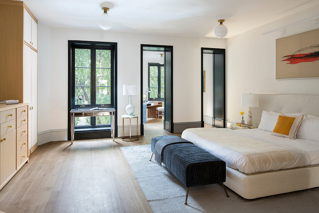 Bright, modern bedroom with black-framed windows, wooden furniture, and plush furnishings.