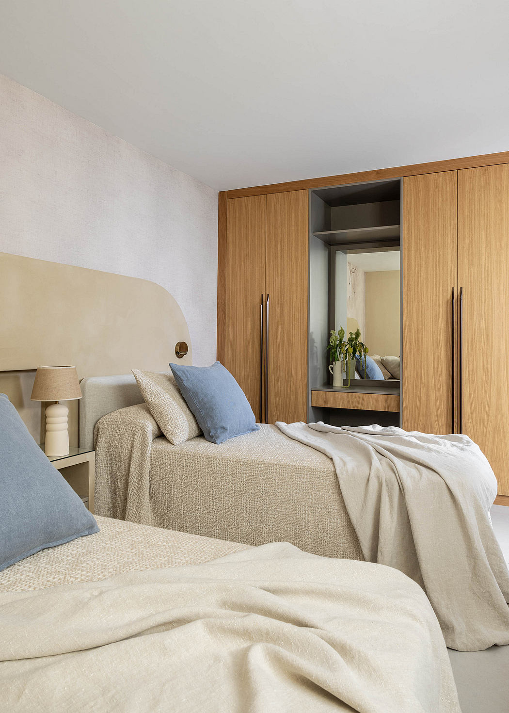 Cozy bedroom with wooden built-in cabinets, neutral bedding, and a minimalist aesthetic.