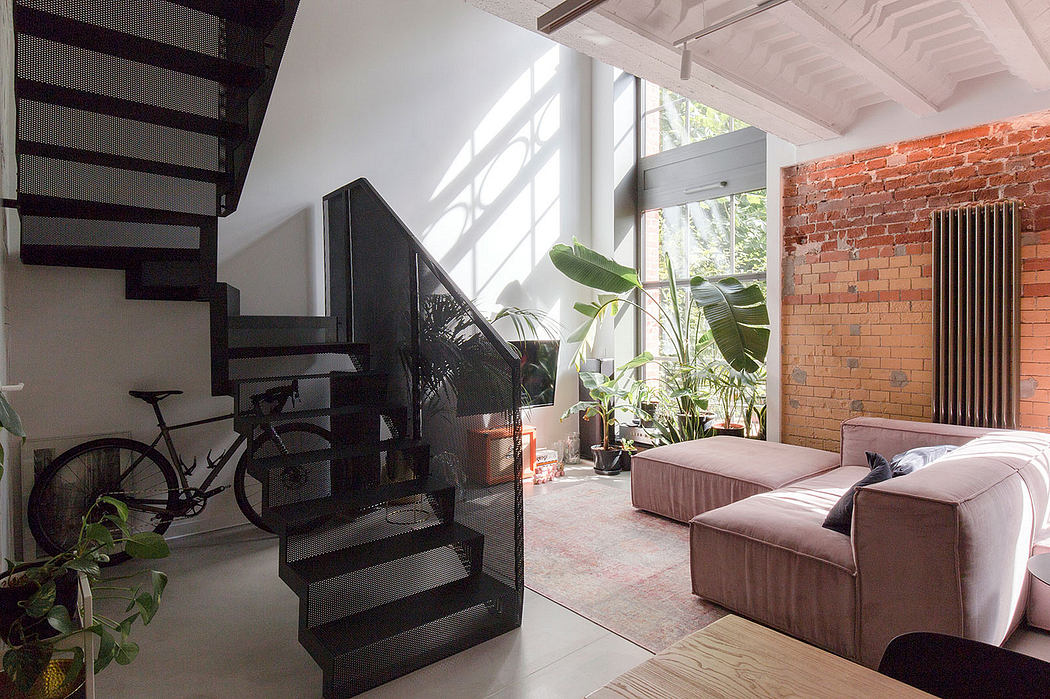 Sleek, modern interior with exposed brick walls, industrial staircase, and lush potted plants.