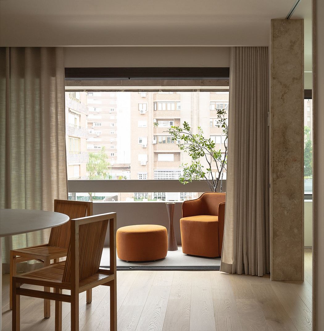Minimalist apartment interior with wooden furniture, large windows, and potted plant.