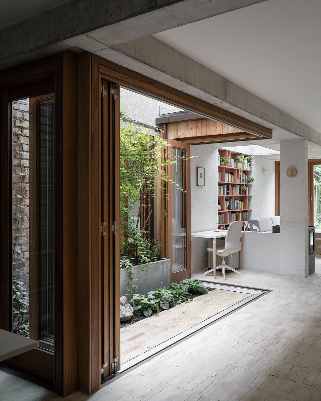 Elegant indoor-outdoor living space with wooden accents, greenery, and a cozy work nook.