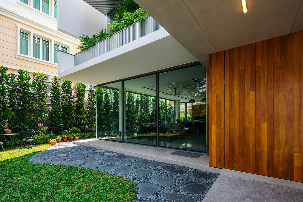 Glass walls overlook a lush, well-maintained garden with wooden accents and textured flooring.