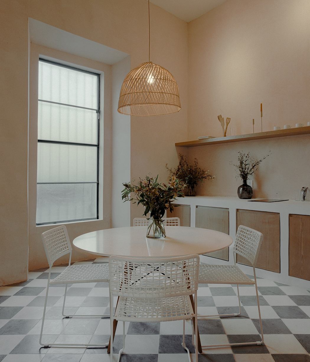 Cozy dining area with woven light fixture, white table and chairs, tiled floor.