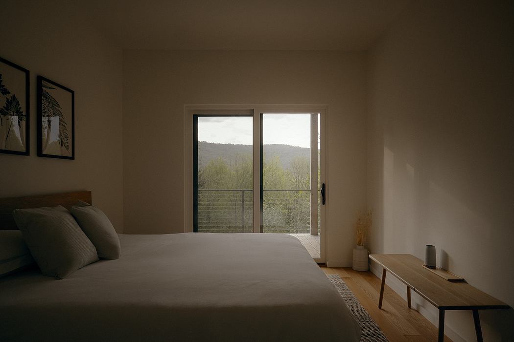 Minimalist bedroom with wood details, large windows overlooking nature.