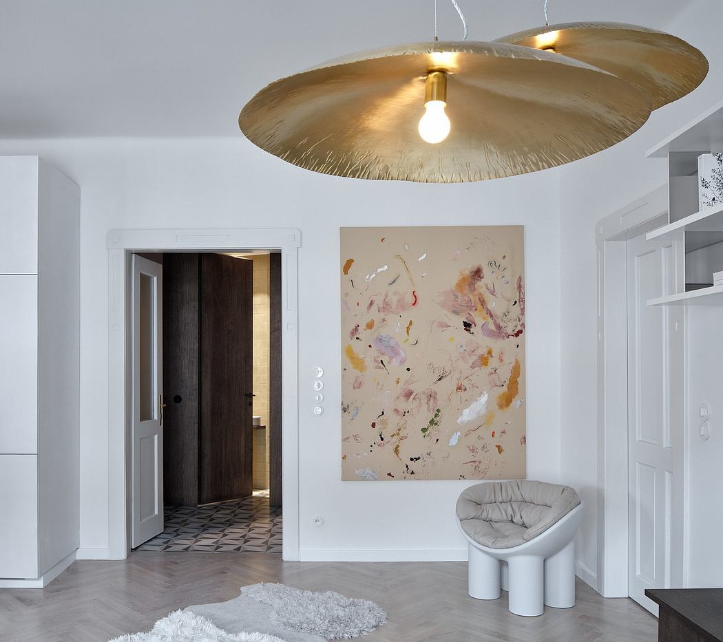 Modern interior with abstract art, gold-toned pendant light, and minimalist seating.