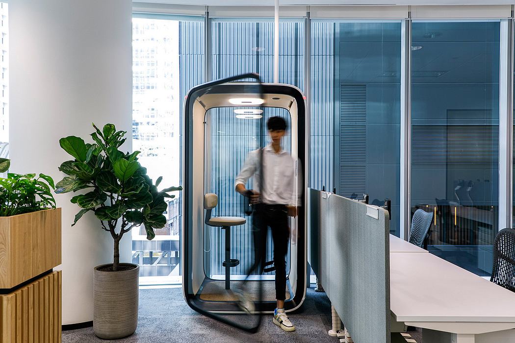 Sleek, modular workspace with standing desk pod and lush greenery accent.