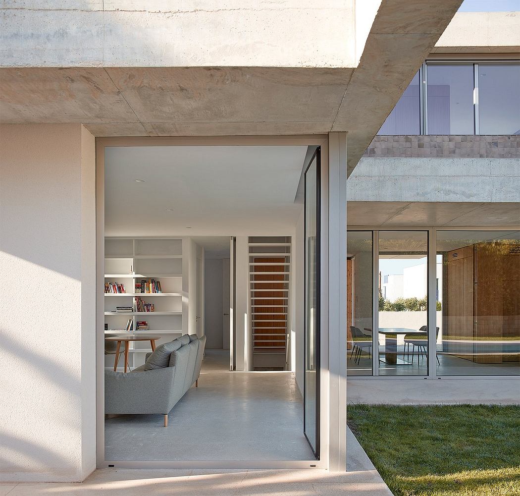A modern concrete home with minimalist interiors, large windows, and an open floor plan.