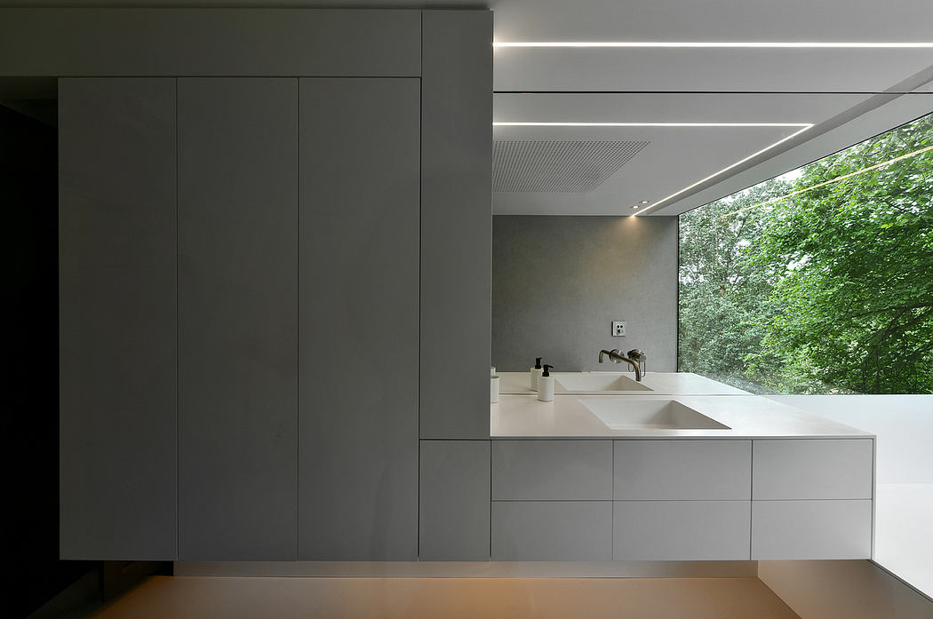 Sleek, modern bathroom interior with minimalist cabinetry and large window overlooking nature.