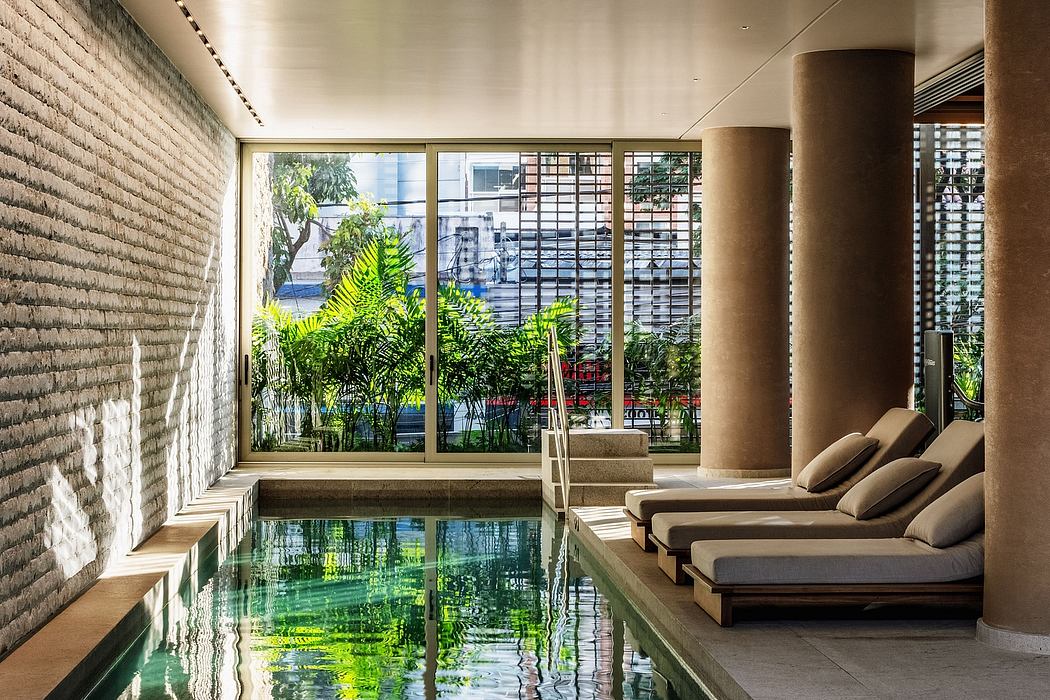 Luxurious indoor pool surrounded by lush greenery and minimalist decor.