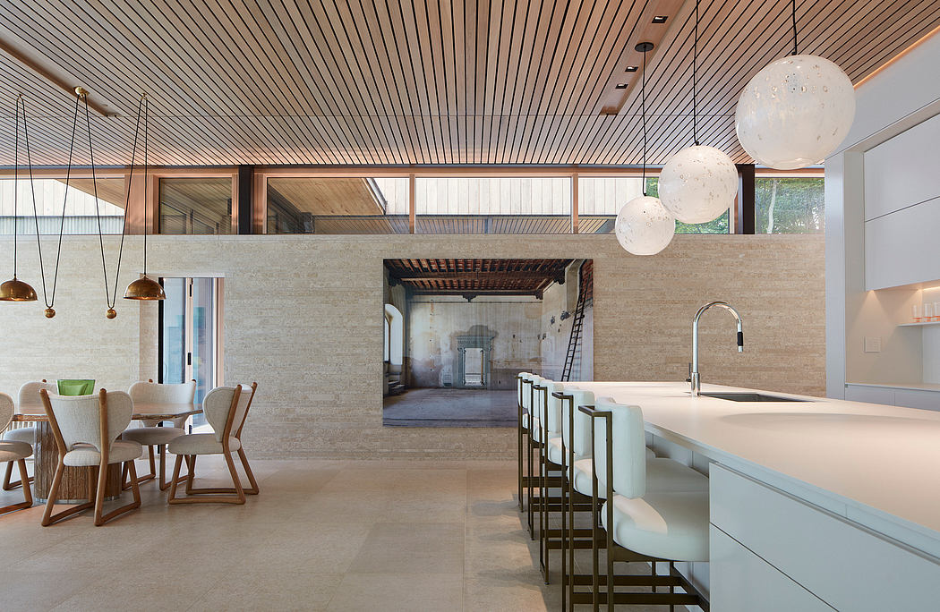 A spacious, open-concept kitchen and dining area with a wooden-paneled ceiling and concrete walls.
