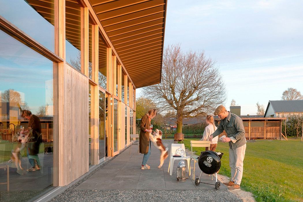 Wooden structure with large windows overlooking a grassy lawn and trees.