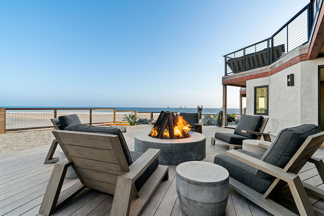Cozy outdoor seating area with fire pit, deck, and panoramic ocean view.