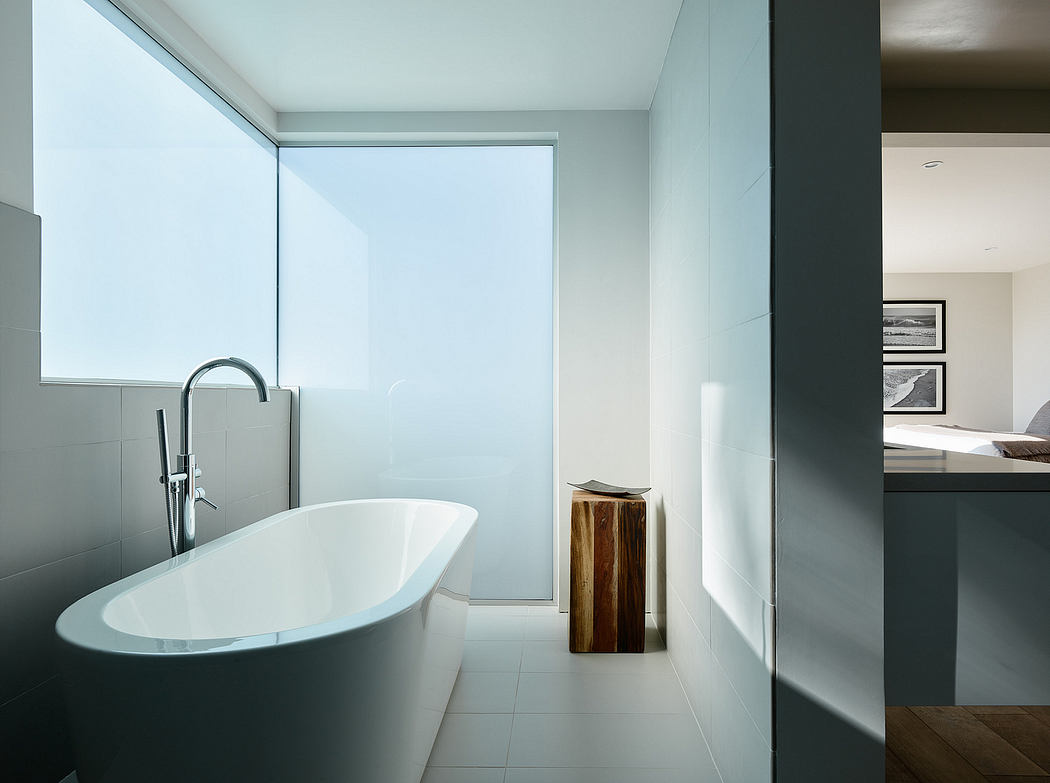 Minimalist, modern bathroom with freestanding bathtub, wooden vanity, and sleek fixtures.