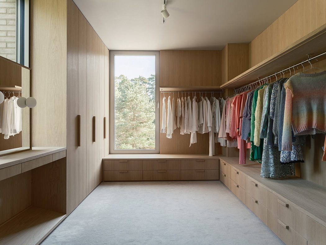 Spacious walk-in closet with wooden storage units, hanging racks, and large window.