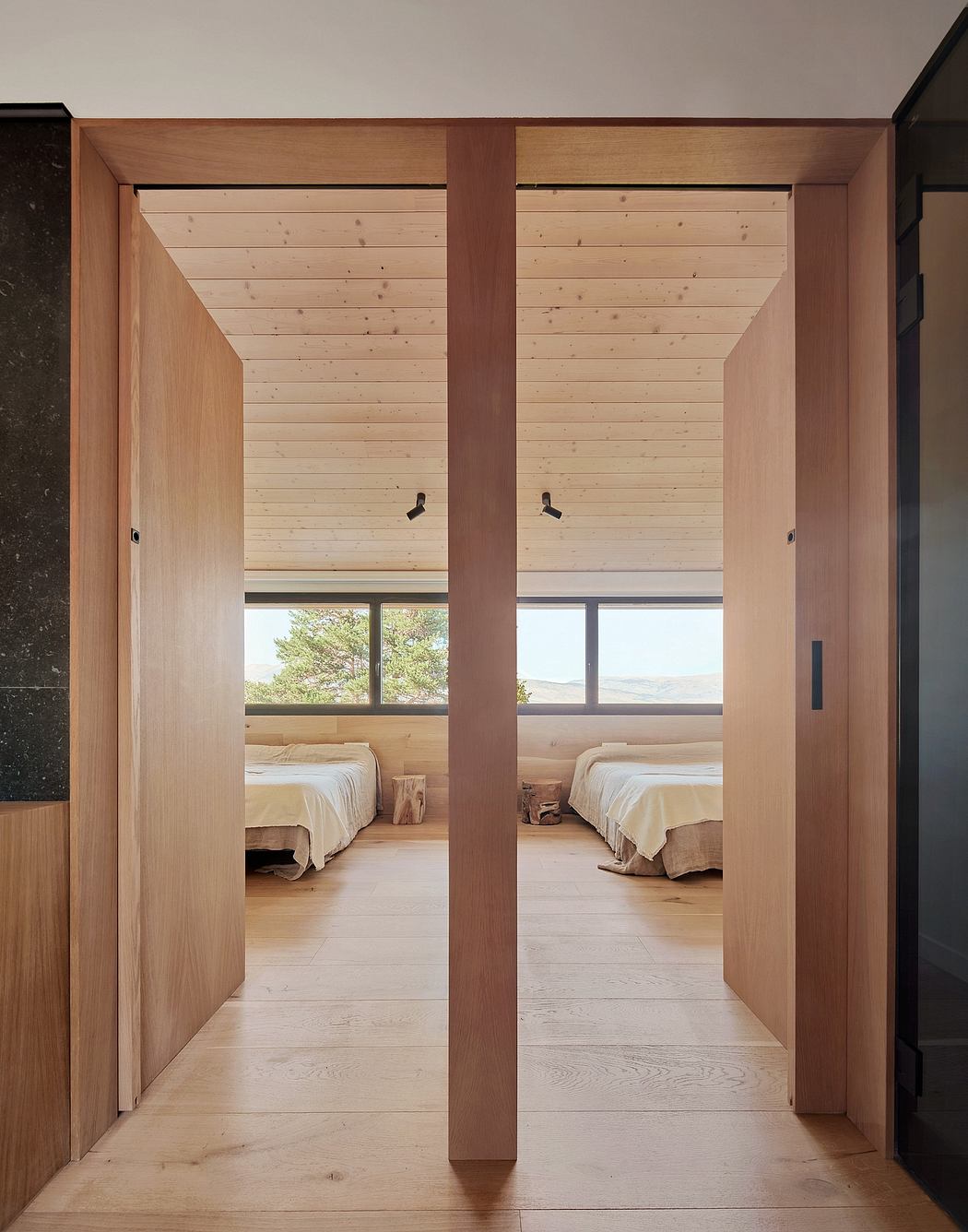 Spacious wooden cabin interior with minimalist design and panoramic windows.