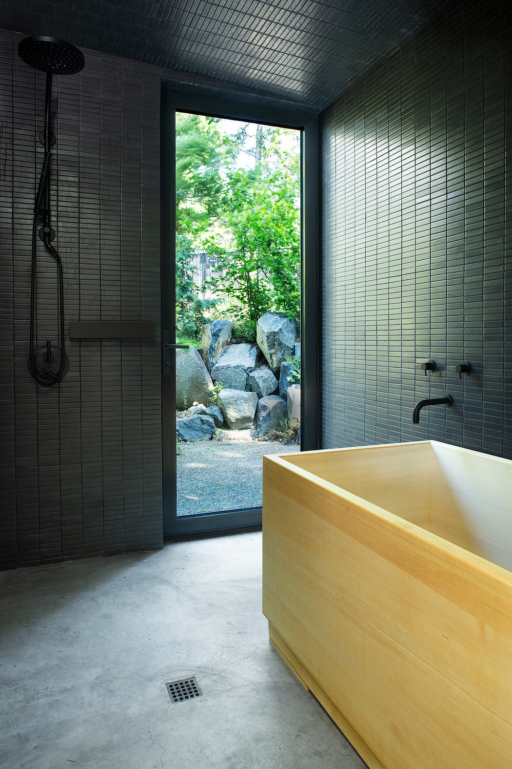 Sleek, modern bathroom with a large window overlooking a rocky outdoor landscape.