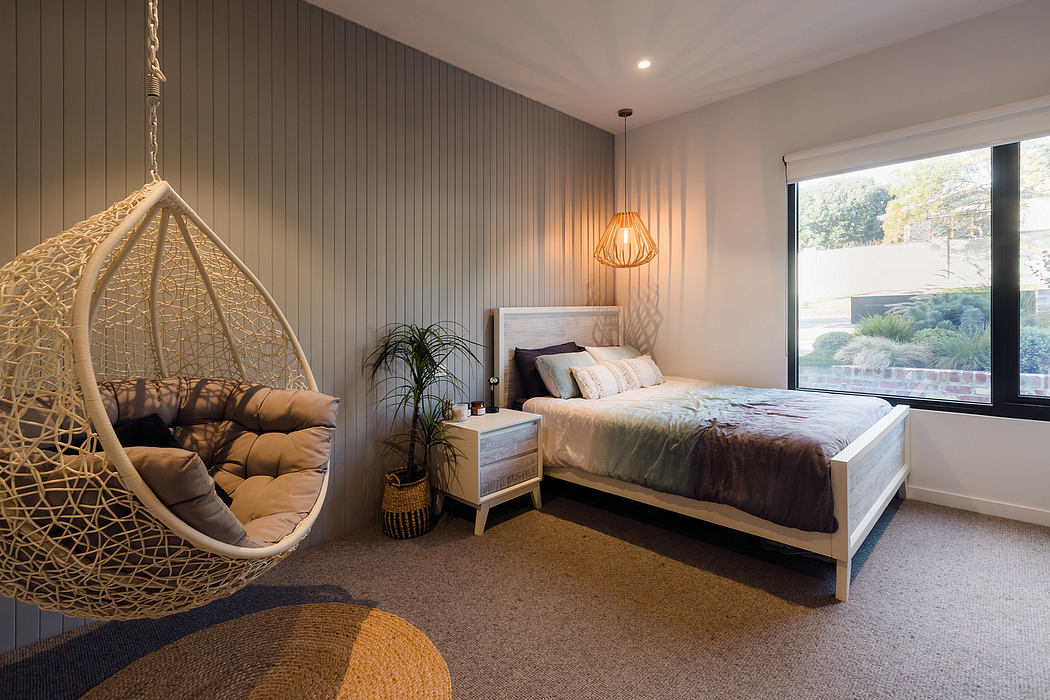 Warm, cozy bedroom with plush hangchair, wood paneling, and contemporary furnishings.