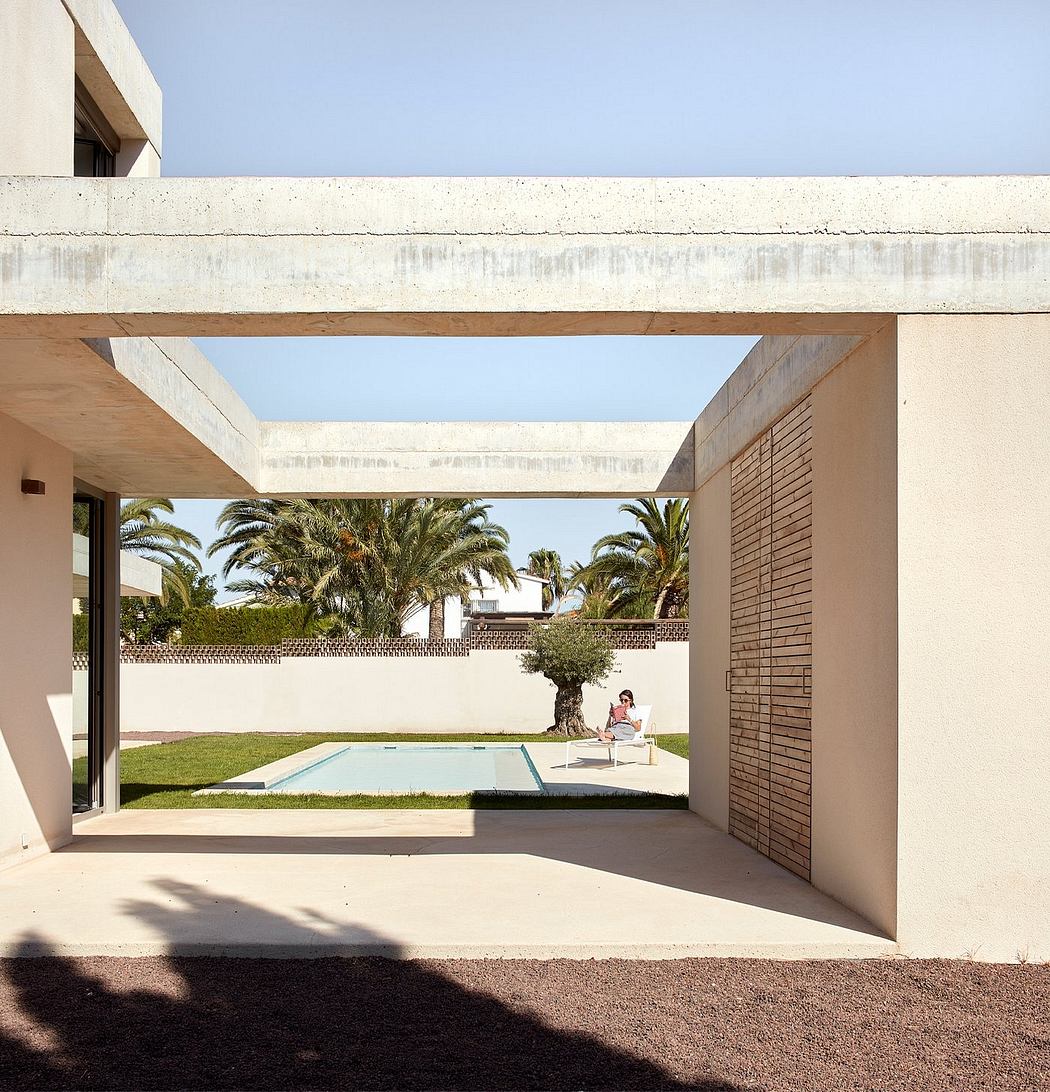Modernist architecture with open-air courtyard, palm trees, and a minimalist pool.